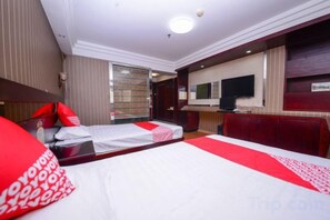 Ein Hotelzimmer mit zwei Betten, einem Fernseher und einer Minibar.