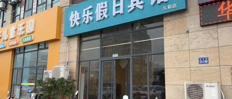 A building with a large glass entrance and a sign that reads 'Happy Day Beauty Hotel.'