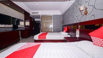 Habitación de hotel con dos camas, un televisor, un minibar y un adornado en la pared.