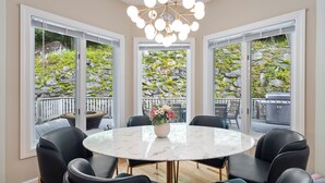 A dining area with a round table, black chairs, and a chandelier.