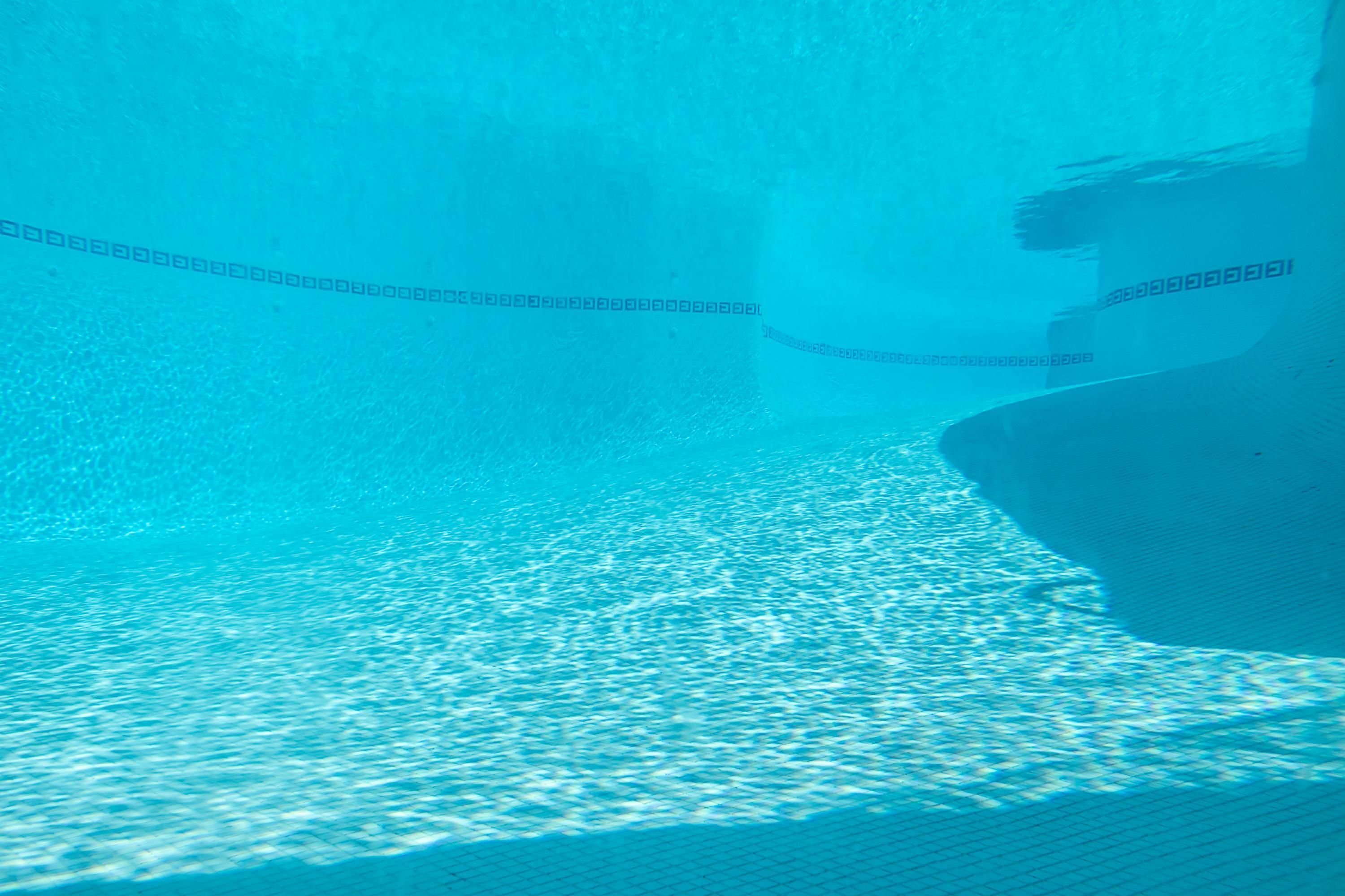 An underwater view of a swimming pool with a visible lane divider.