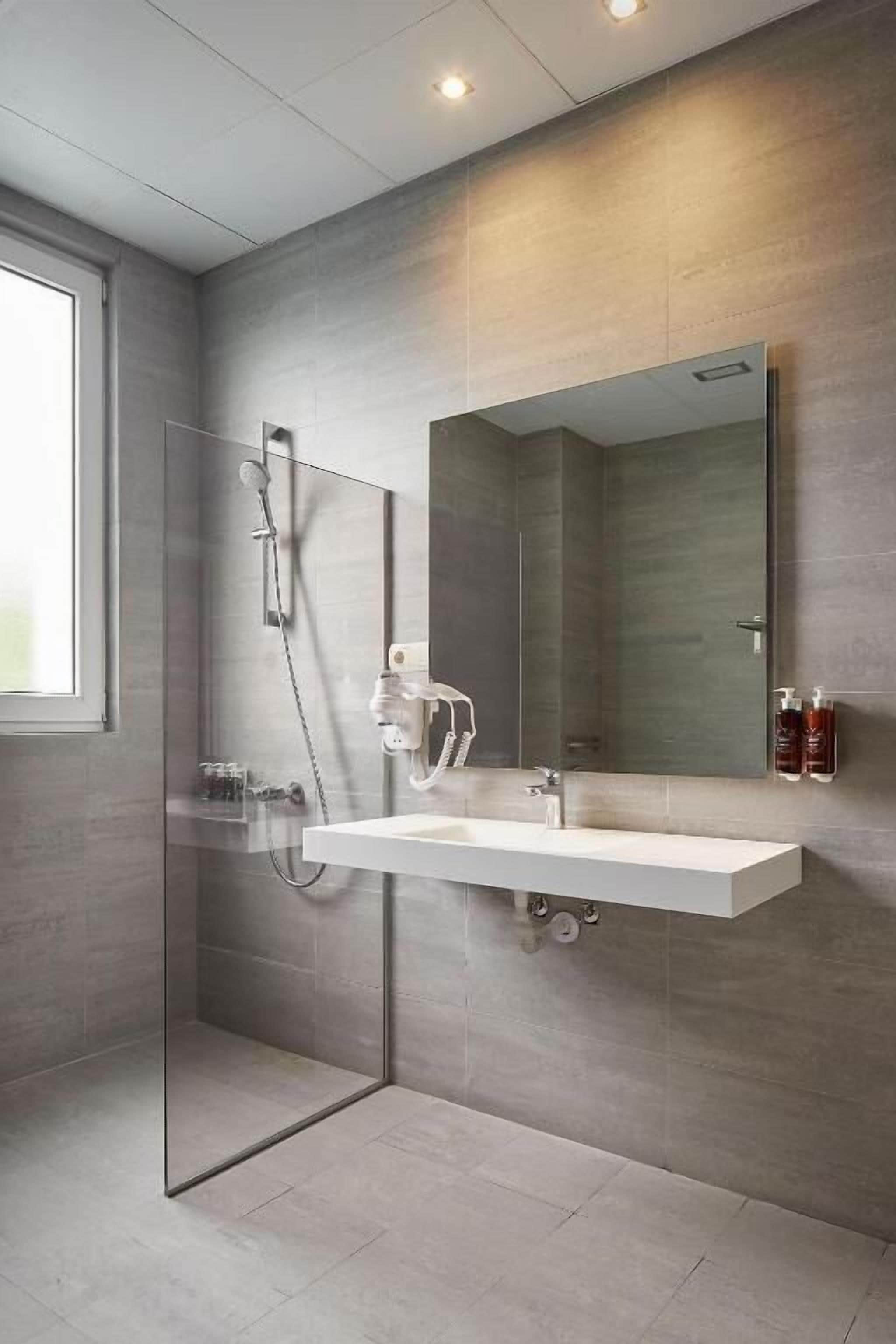Twin kamer, toegankelijk voor rolstoelgebruikers | Badkamer | Een haardroger, een bidet, handdoeken, zeep