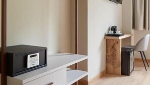 A modern room with a bed, a desk, a chair, a TV, and a wardrobe. - Hotel Sukha (Eskoriatza)