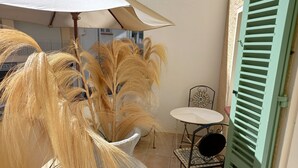 A balcony with a potted plant, a table, and a chair. - 2 ROOM APARTMENT NEAR THE SEA AND PINES OF JUAN-LES-PINS (Antibes)