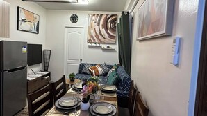 Un espacio habitable compacto con comedor, kitchenette y sofá.