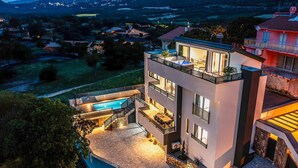 A modern two-story house with a swimming pool, outdoor seating, and a view of the surrounding landscape. - Villa Betelgeuse Supernova (Novi Vinodolski)