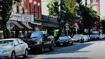 A street lined with parked cars and buildings, including a sign for Chatham Wine & Liquor.