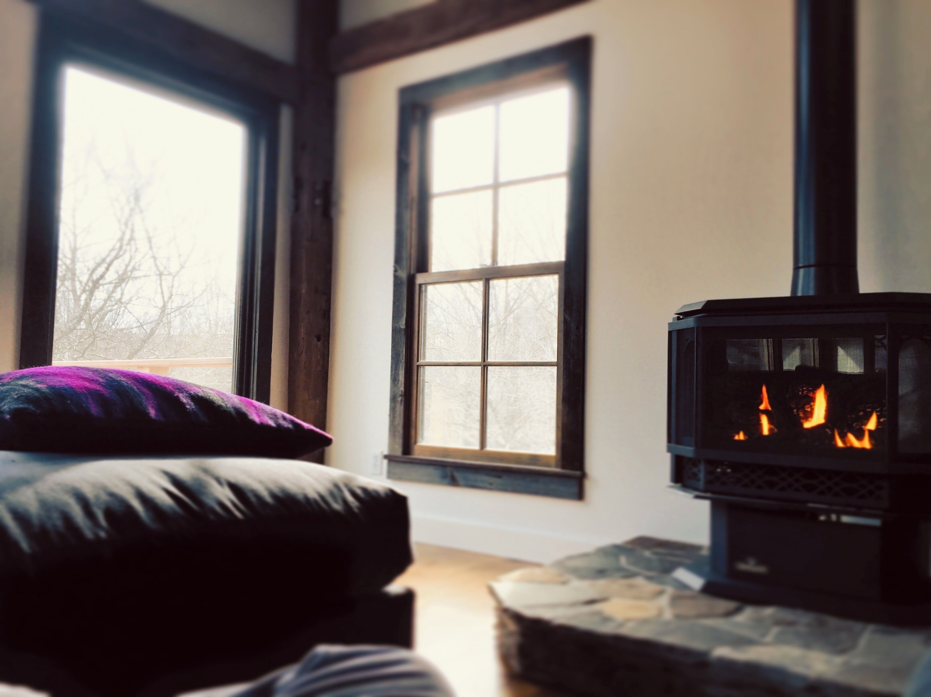 Una habitación acogedora con chimenea, ventana y cama.