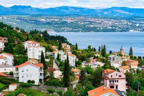 Une ville côtière avec des bâtiments construits sur une colline, dominant une étendue d’eau.
