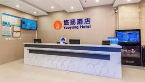 Eine Rezeption im Youyang Hotel mit Marmordesign, einem digitalen Bildschirm und Informationspostern an der Wand.