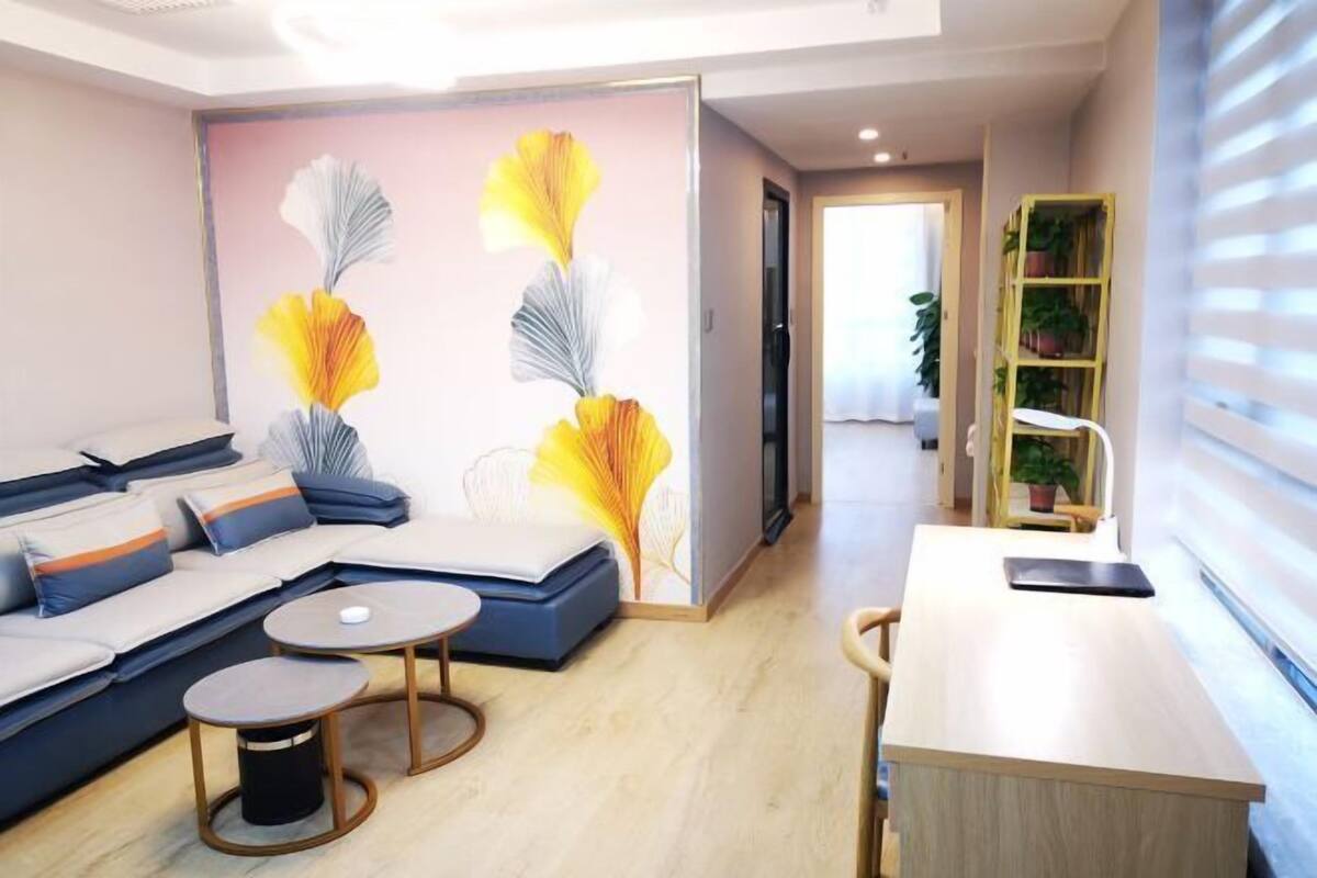 A modern living room with a sofa, coffee table, and a small dining area.