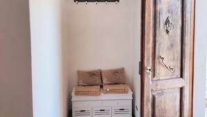 A hallway with a white bench, a wooden door, and a wall-mounted light fixture. - Toskana Haus in Bigliolo mit Toller Aussicht, Garten, Sonne, in Flussnähe (Bigliolo)