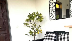 A cozy room with a wooden bench, a small table, a wicker basket, and a potted plant. - Toskana Haus in Bigliolo mit Toller Aussicht, Garten, Sonne, in Flussnähe (Bigliolo)