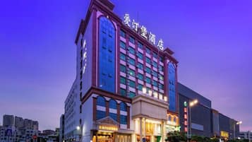 Un hotel de varios pisos con una entrada destacada y señalización.