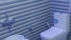 A bathroom with a toilet, bidet, and a small blue stool. - Osho cottage  (Rajnagar)