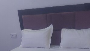 A bed with white bedding and a wooden headboard. - Osho cottage  (Rajnagar)