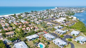An aerial view of a coastal residential area with houses, a beach, and a marina. - Beachy Butterfly! Poolside Holmes Beach Stay! (Holmes Beach)