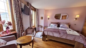 A bedroom with a bed, a chair, a small table, and a window with curtains. - Comfortable room with private bathroom (Pierrepont)
