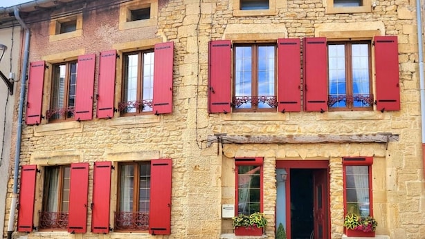 A two-story stone building with red shutters on windows and doors. - Comfortable room with private bathroom (Pierrepont)