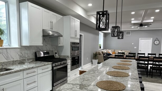 A modern kitchen with white cabinets, granite countertops, and stainless steel appliances. - Caton Manor Estate and Pool (Catonsville)