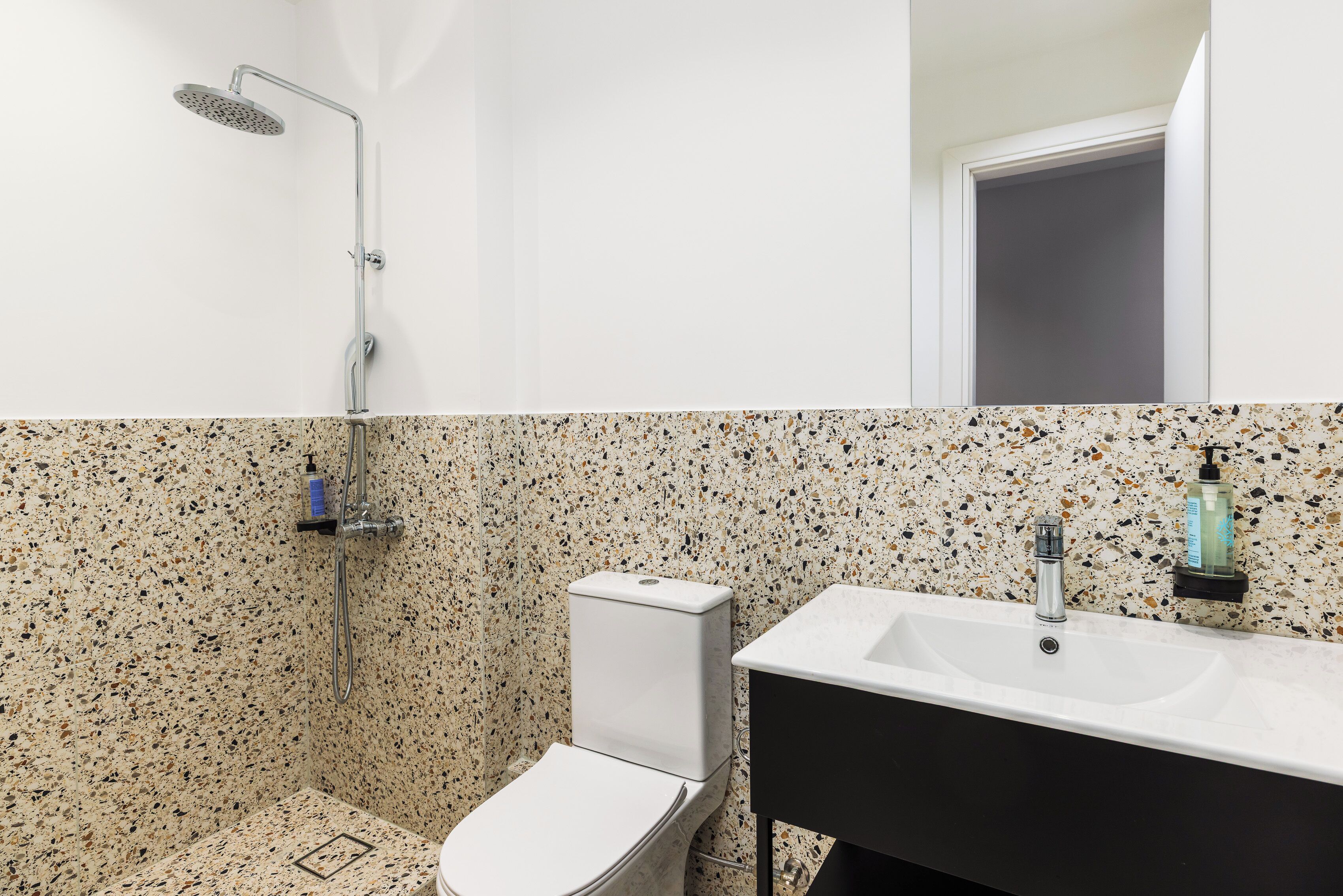 Ein Badezimmer mit Dusche, Toilette und Waschbecken.