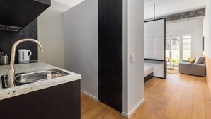 A modern kitchen with a stainless steel sink and a black cabinet. - Soho Residence by halu! (Thessaloniki)