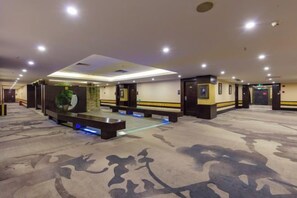A hotel lobby with a carpeted floor, a reception desk, and a seating area. - Jin Yu Hotel (Zhuhai Gongbei Port Pedestrian Street) (Zhuhai)