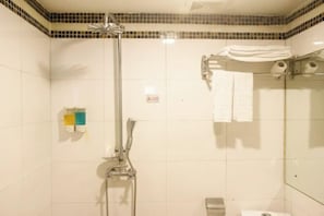 A shower with a handheld showerhead, a glass enclosure, and a towel rack with folded towels.