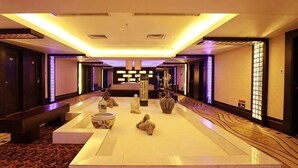 A hotel lobby with a central seating area, a large bed, and a reception desk. - Jin Yu Hotel (Zhuhai Gongbei Port Pedestrian Street) (Zhuhai)
