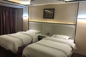 A hotel room with two beds, a nightstand, a lamp, and a painting on the wall. - Jin Yu Hotel (Zhuhai Gongbei Port Pedestrian Street) (Zhuhai)