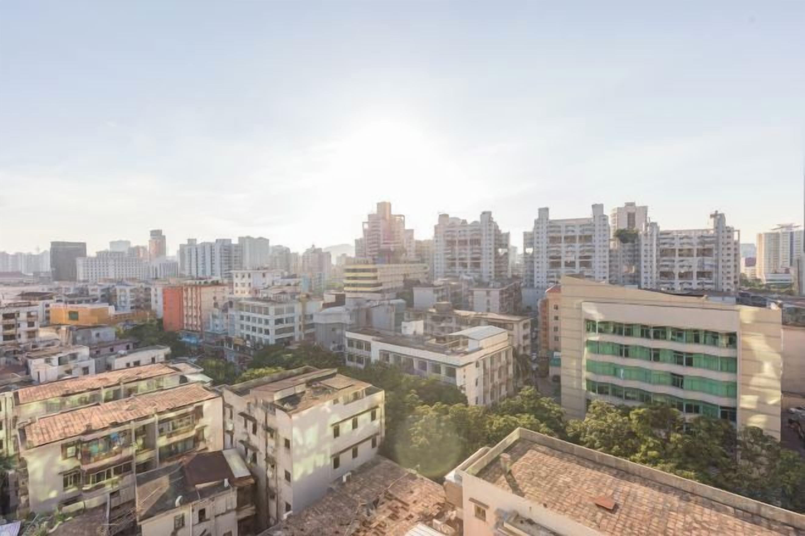 A cityscape with multiple high-rise buildings, some with visible windows and balconies.