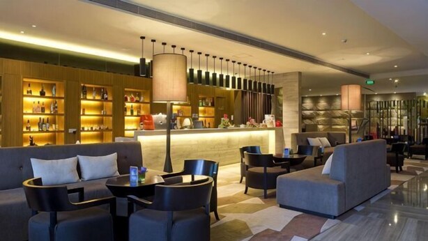 A lobby with sofas, chairs, a bar area, and a reception desk. - Jin Yu Hotel (Zhuhai Gongbei Port Pedestrian Street) (Zhuhai)