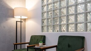 Two green armchairs with wooden armrests and legs, a floor lamp, and a window with a grid pattern. - In Front of the Underground and 8 Minutes From the Beach Sf228 (Rio de Janeiro)