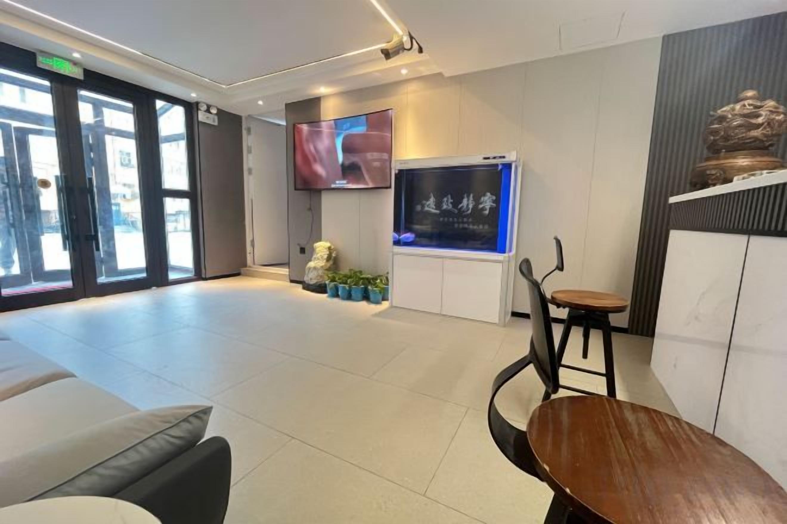 A reception area with a TV, seating, and a decorative wall.