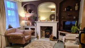 A cozy living room with a fireplace, a sofa, a TV, and a decorative rug. - Lavender Cottage, a pretty period cottage in Louth (Louth)