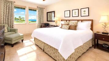 A hotel room with a large bed, a desk, a chair, and a view of the outdoors.