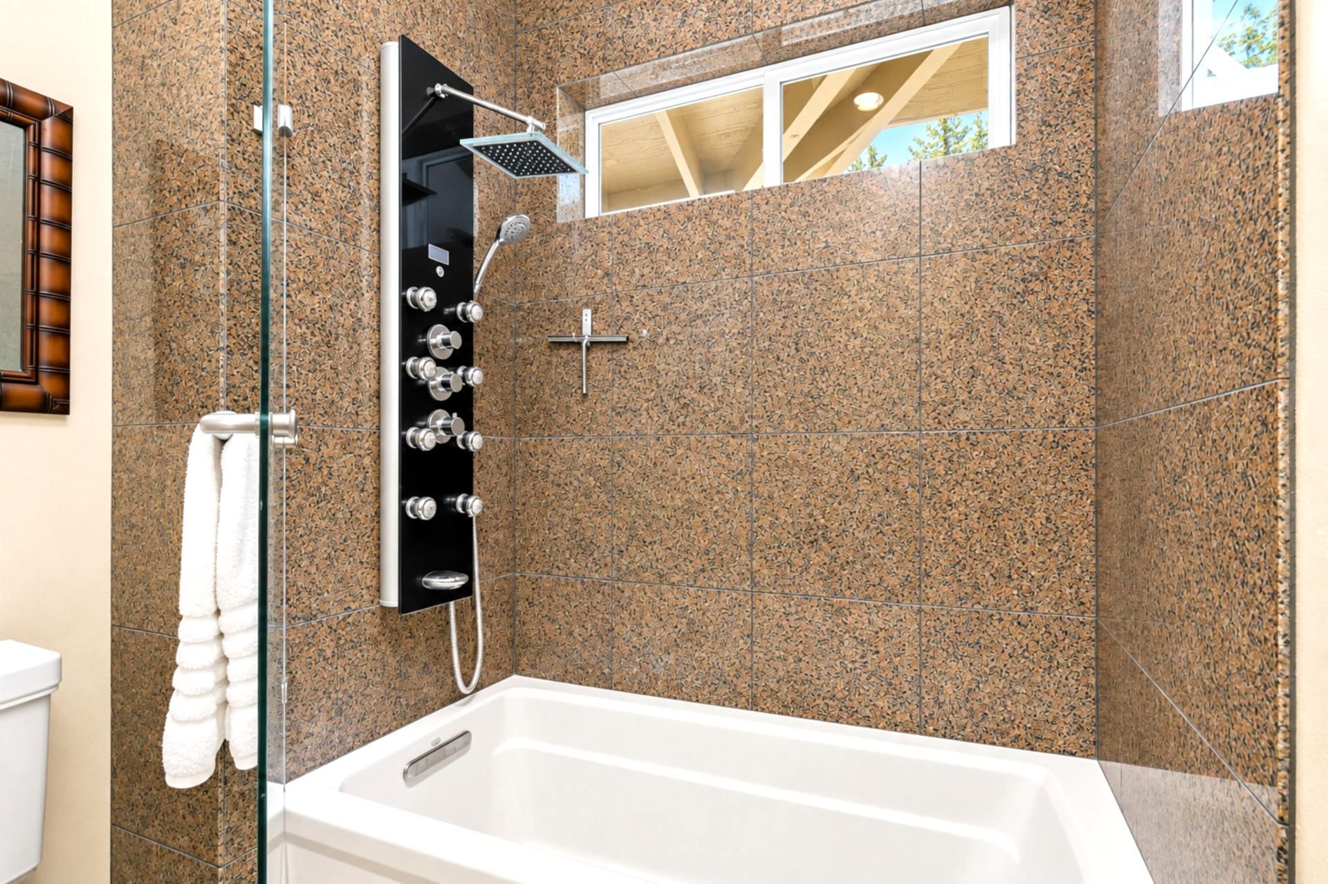 A modern bathroom with a freestanding bathtub, a glass-enclosed shower, and a towel rack.