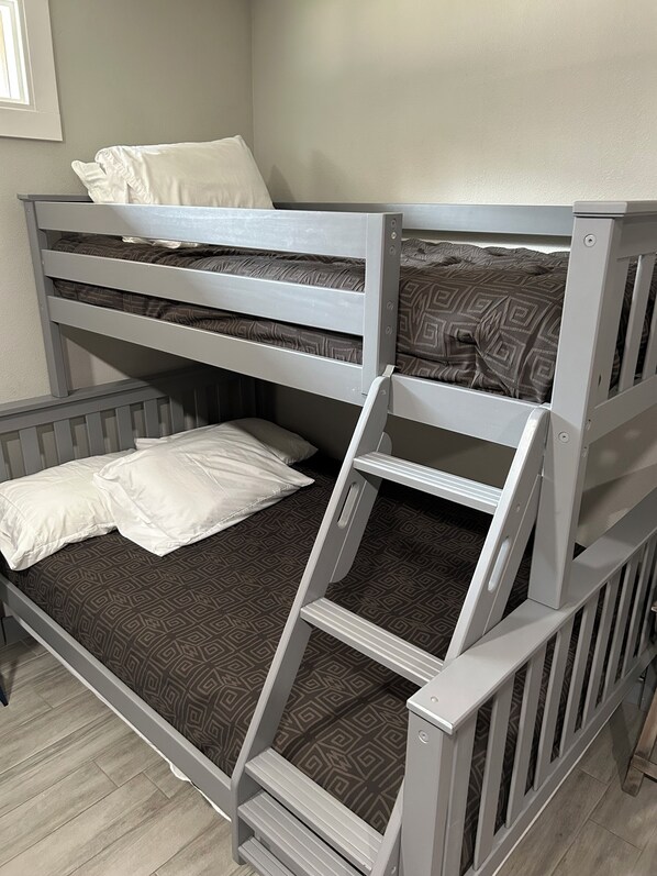 Una cama litera con escalera, una cama inferior y cabecero.