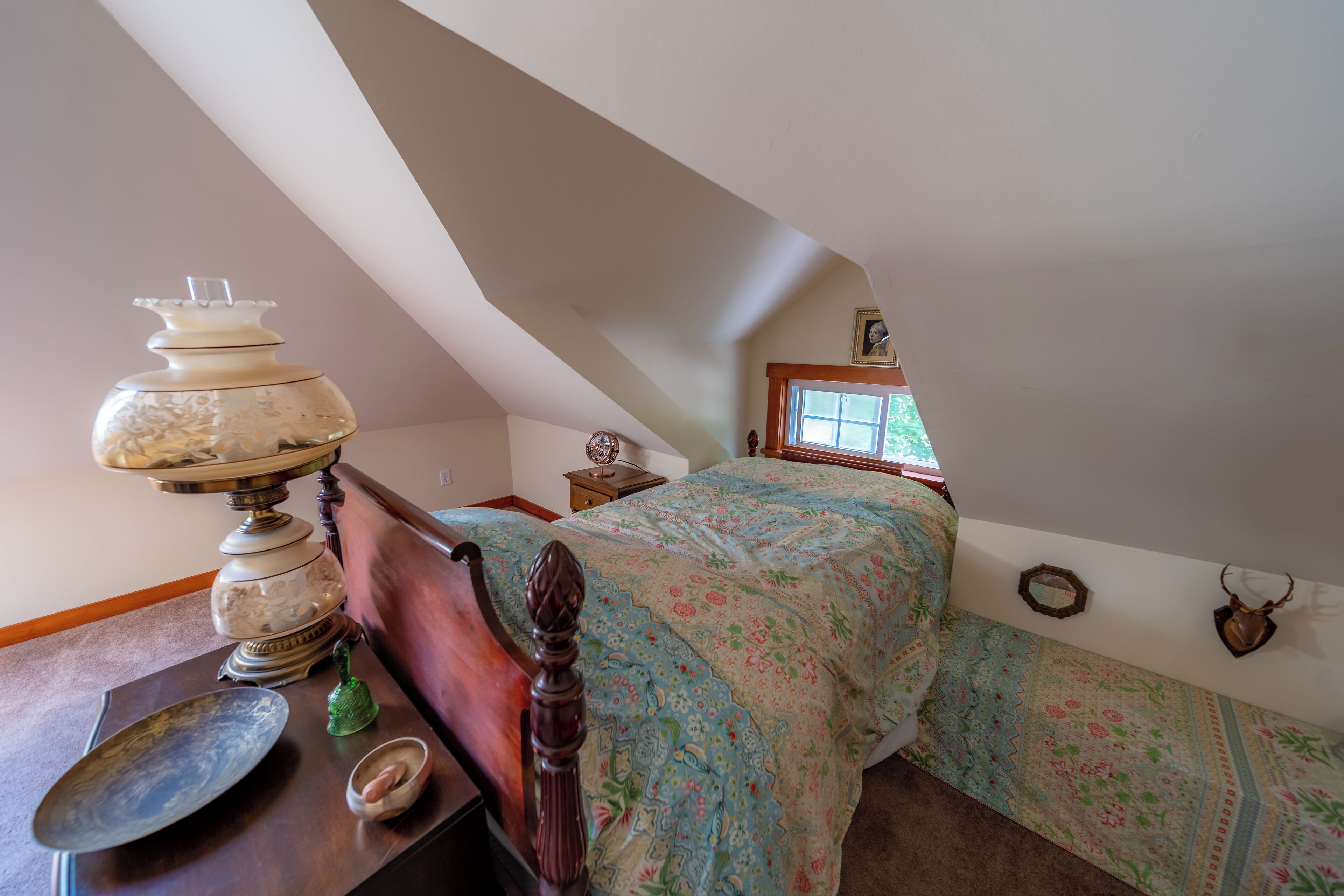Un dormitorio con una cama de madera, una lámpara decorativa y un ventanal con vistas.
