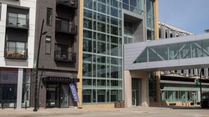 A modern building with a glass facade, a visible entrance, and a sign for 'Five Fifty'. - Modern Studio Apt with Rooftop, Gym, and Parking (Milwaukee)