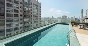 Una piscina al aire libre, sillones reclinables de piscina