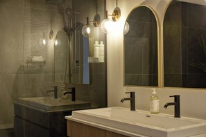 A modern bathroom with two sinks, a large mirror, and a shower. - 201 Verbier Building 7 (Mont-Tremblant)