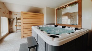 Un baño moderno con bañera independiente, paneles de madera, un espejo grande y un banco.
