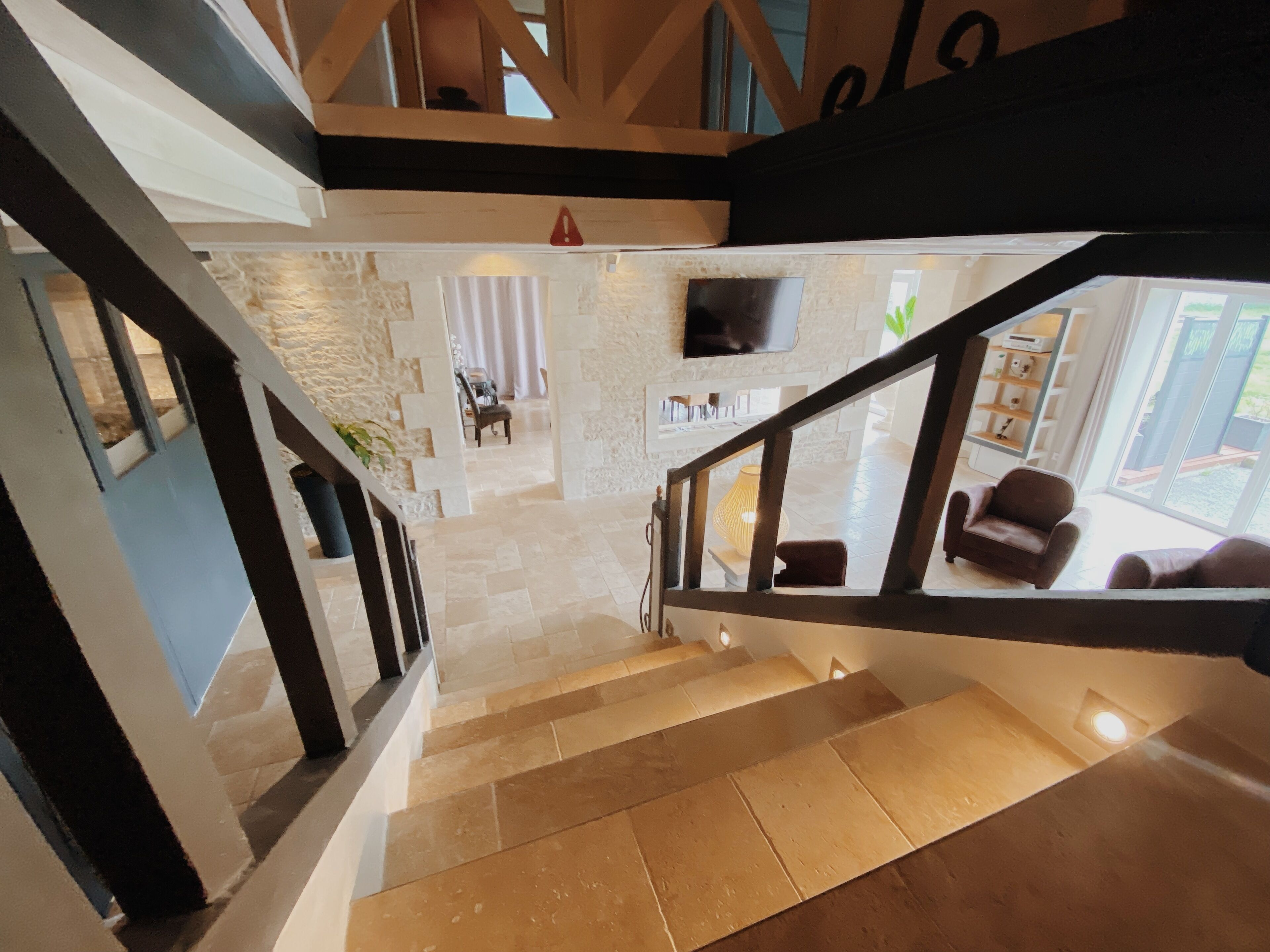 A staircase leading to a living area with a TV, a sofa, and a coffee table.
