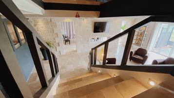 A staircase leading to a living area with a TV, a sofa, and a coffee table.
