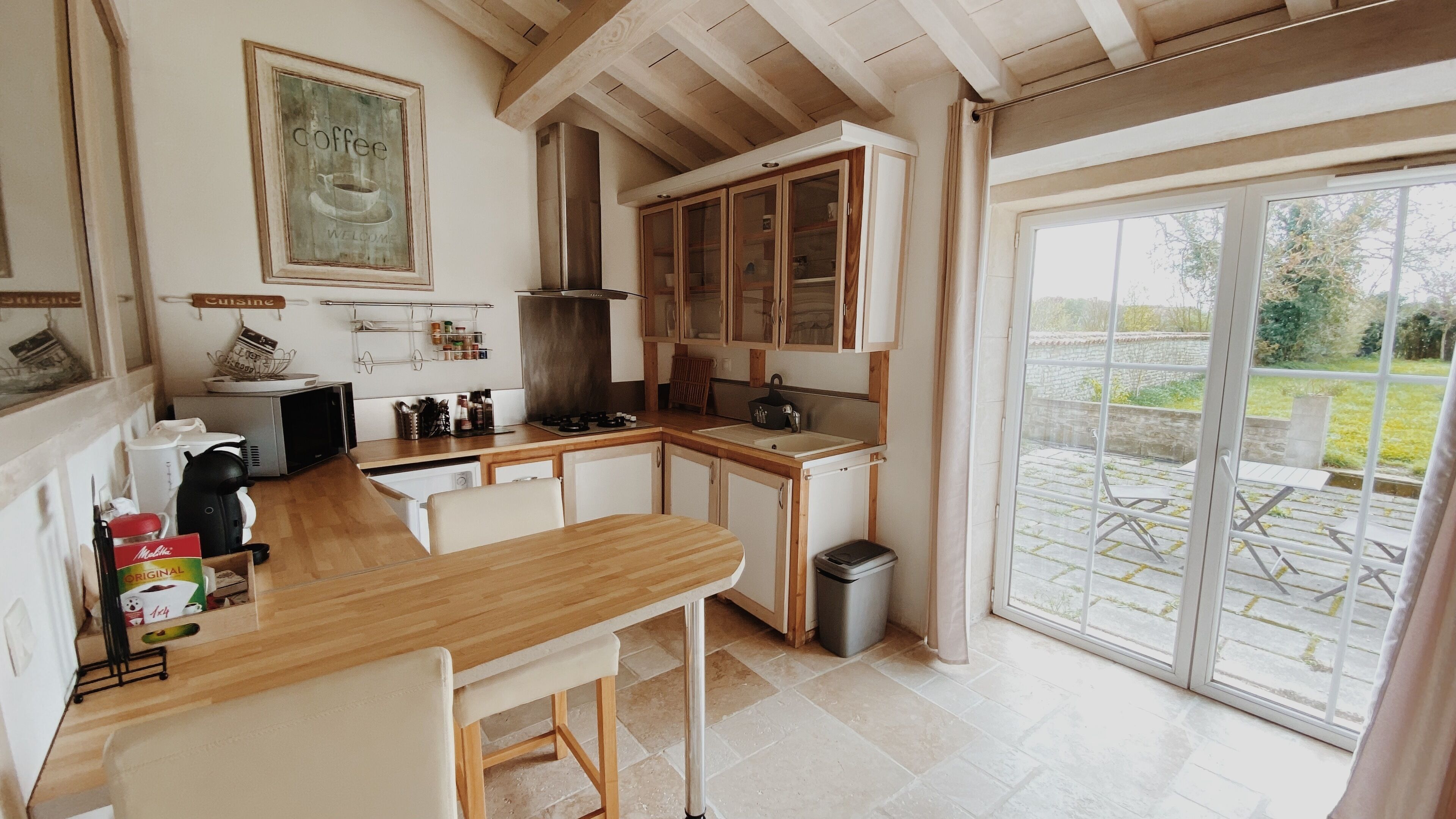 A kitchen with wooden cabinets, a sink, and a dining area with a bench.