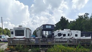 Een RV-camping aan het water, met verschillende campers afgemeerd aan een houten steiger.