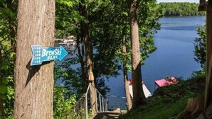Indicador del punt de partida de Brewski Run, envoltat d'arbres i un llac.