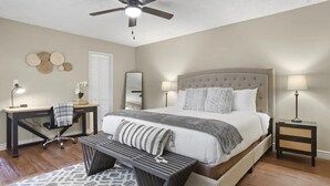 A bedroom with a bed, desk, chair, and a ceiling fan. - Large Pool, Near State Farm STDM and Many Entertainment Districts! (Peoria)