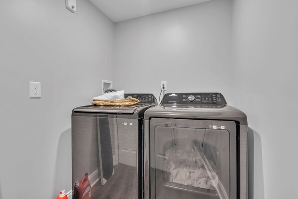A laundry area with two front-loading washing machines and a dryer. - Game Room | High Speed WIFI | EV Charger | Keurig (Seaside Heights)
